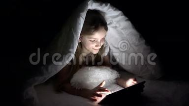 孩子在黑夜里玩平板电脑，女孩在床上上网，不睡觉